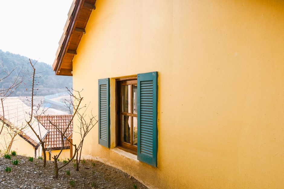 A yellow painted house with blue shutters.