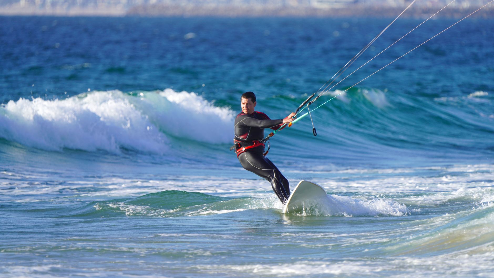 A kitesurfer riding ocean waves