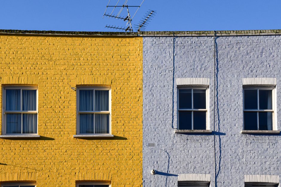Yellow and blue painted house walls side by side.
